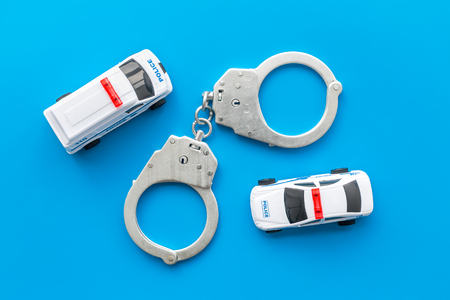 Police concept. Police car toy and handcuff on blue background top viewの写真素材