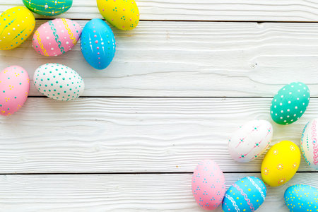 Easter composition. Decorated pastel Easter eggs on white wooden background.