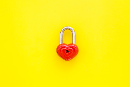 Valentine's day concept. Lock in shape of heart on yellow background top view.の写真素材