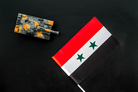 War, military threat, military power concept. Syria. Tanks toy near Syrian flag on black background top viewの写真素材