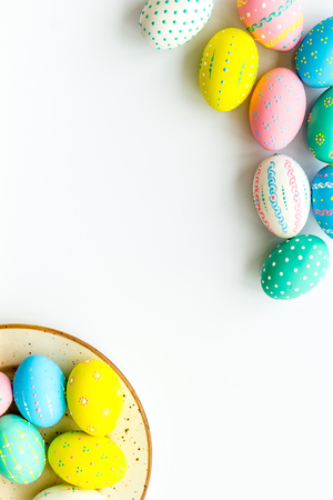 Festive Easter table. Colorful Easter eggs on plate on white background top view.の写真素材