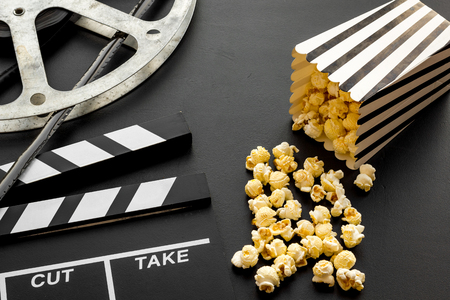 Cinema concept. Clapperboard, film stock and popcorn on black backgroundの写真素材