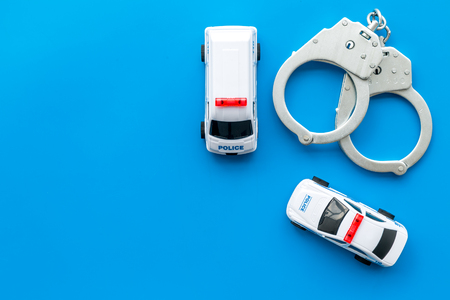 Police concept. Police car toy and handcuff on blue background top view copy spaceの写真素材