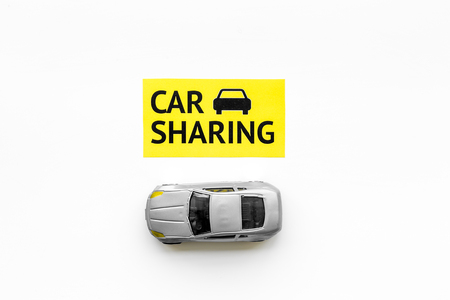 Carsharing concept. Toy car near text car sharing on white background top view.の写真素材