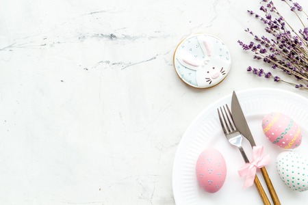 Easter table setting. Tableware and painted eggs on white background top view.の写真素材