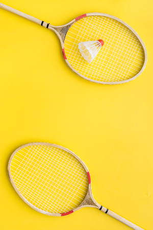 Badminton concept. Badminton rackets and shuttlecock on yellow background top view.の写真素材