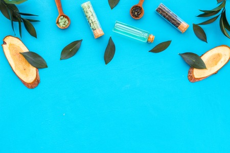 Natural organic cosmetics with tea tree essential oil near fresh tea tree leaves on blue background top view space for text borderの写真素材