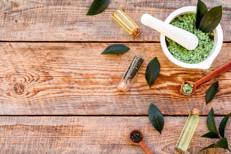 Make cosmetics with tea tree essential oil. Homemade cosmetics. Fresh tea tree leaves, mortar and pestel, cosmetics on rustic wooden background top view border space for textの写真素材