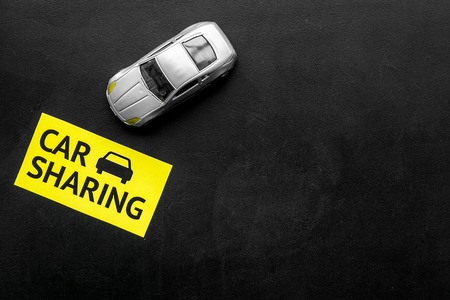 Car sharing concept. Toy car near text car sharing on black background top view space for textの写真素材