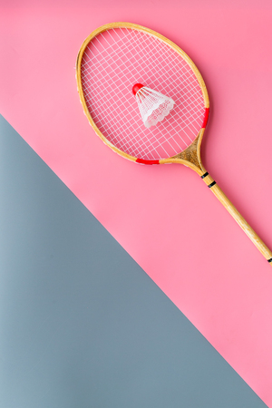 Badminton equipment. Badminton racket and shuttlecock on pink and grey background top view space for textの写真素材