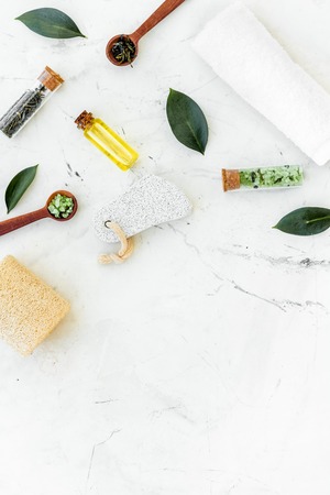 Tea tree spa composition. Fresh tea tree leaves, natural cosmetics, towel on white stone background top view copy space borderの写真素材