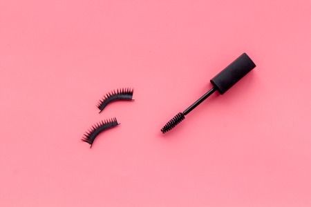 Decorative cosmetic set with mascara on pink woman desk background top view mock upの写真素材