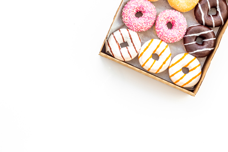 Glazed decorated sweet donuts in box on white background flat lay mock upの写真素材