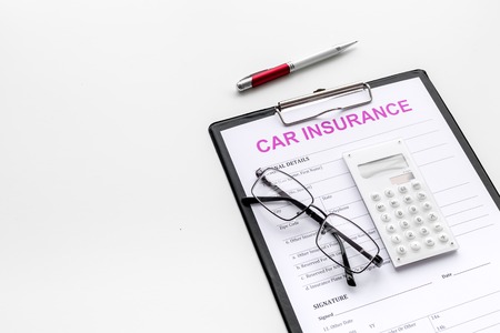 Car insurance form near glasses, calculator, pen on white background.の写真素材
