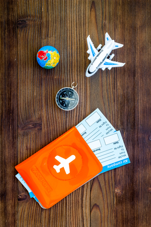 SOS Save the planet and ecology concept with the earth, compass, passport and plane on dark wooden background top view.の写真素材
