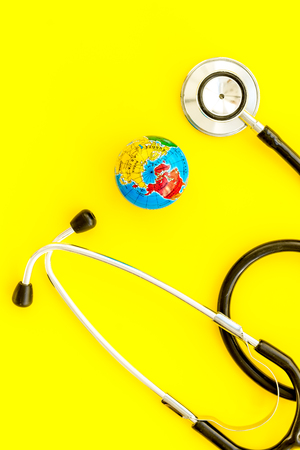 SOS Save the planet and ecology concept with the earth and phonendoscope on yellow background top view.の写真素材