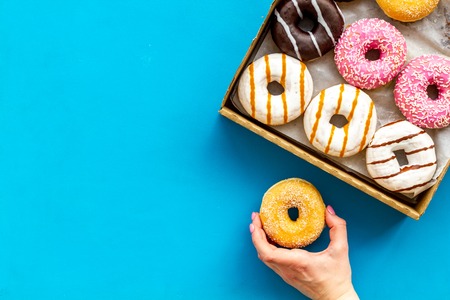 Modern design with donuts in box on blue background top view space for text.の写真素材