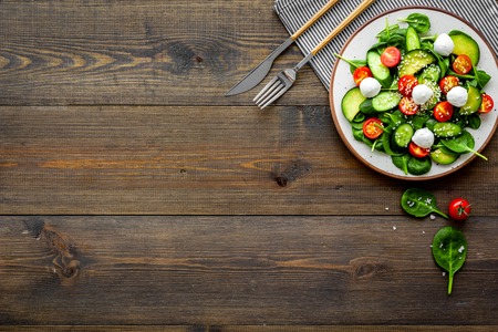 Vegetarian meal. Fresh vegetable salad on dark wooden background top view.の写真素材