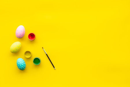 Traditional Easter eggs for colorful paint on yellow table background top view space for text