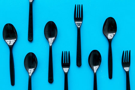 Ecology. Plastic utilization and the Earth protection concept with flatware on blue background top...