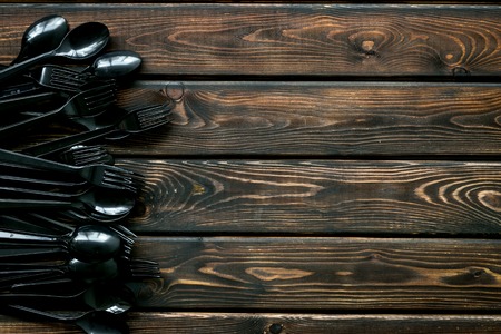 Ecology. Plastic utilization and the Earth protection concept with flatware on wooden background top view mock upの写真素材