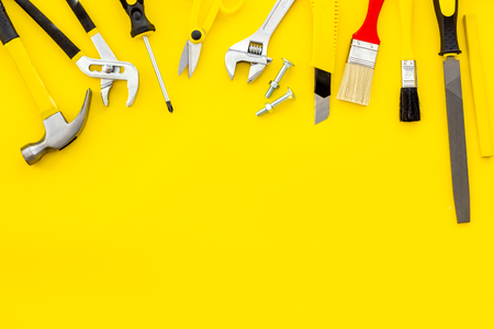Constructor desk with set of building implements and brushes yellow table background top view mock upの写真素材