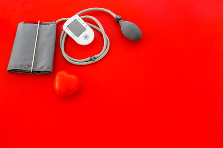 Desk of doctor in hospital. Cardiologist work desk with pulsimeter for diagnostic on red background...