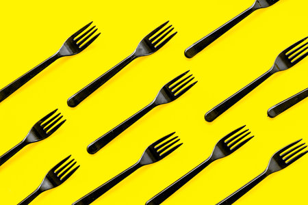 Plastic flatware for eco concept on yellow background top view.の写真素材