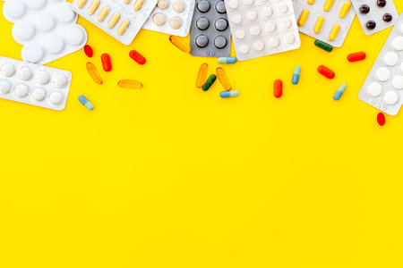 Medical pills, antibiotics taking for care and health on yellow table background top view space for...