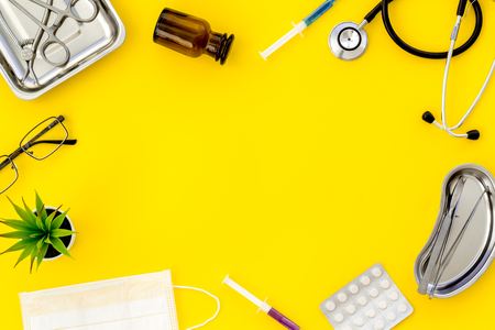 work desk of doctor in hospital with medical set frame on yellow background top view mockupの写真素材