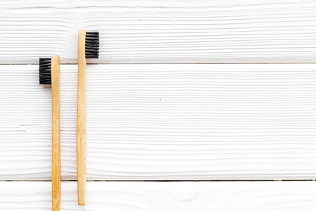 Bamboo dental cleaning brush for zero waste lifestyle concept on white wooden background top view mock up.の写真素材