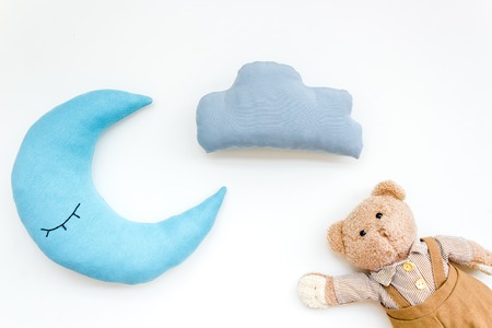 Care about new born. Family concept. Moon pillow, clouds and teddy bear for put newborn in bed on white background top viewの写真素材