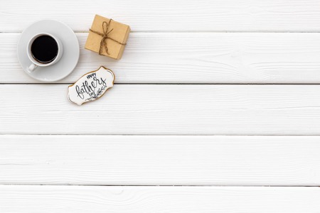 Cup of black coffee, box with gift and copy for Happy Father Day celebration party on white wooden background top view copy spaceの写真素材