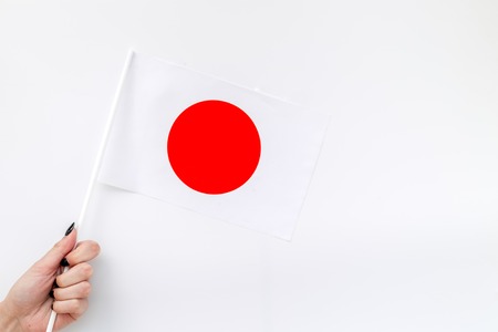 Independence Day of Japan concept with flag in hand on white  top view.の写真素材