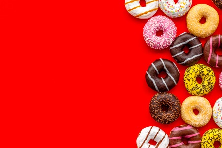 Sweet break concept. Traditional american donuts of different flavors on red  flat lay mockupの写真素材