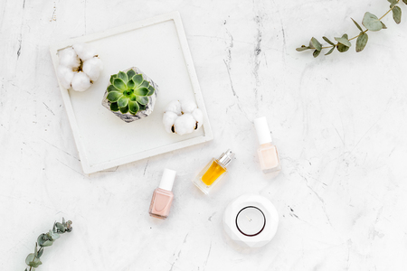 modern design of work desk with nail polish and perfume on white marble background top viewの写真素材