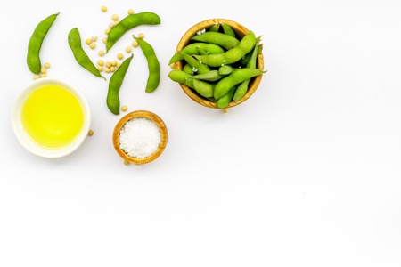 Ingredients. Green soybeans or edamame and oil for fresh healthy organic food on white background top view space for textの写真素材