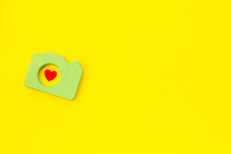 Photo camera concept with heart on yellow background top view mock up.の写真素材