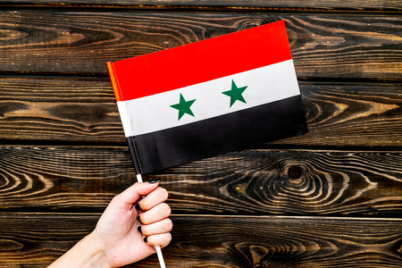 Flag of Syria in hand on wooden background top view.の写真素材