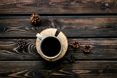 Wooden sawcut. Cup of coffee, wooden stumps and pine cones for blog background on rustic background top viewの写真素材