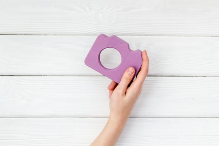 Photo camera concept with hand on white background top view mock up.の写真素材