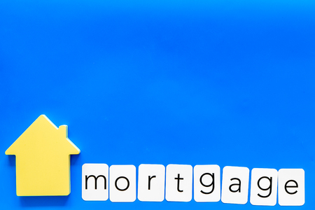 Purchasing a new property on credit. Mortgage copy for credit concept with house toy on blue background top view copy spaceの写真素材
