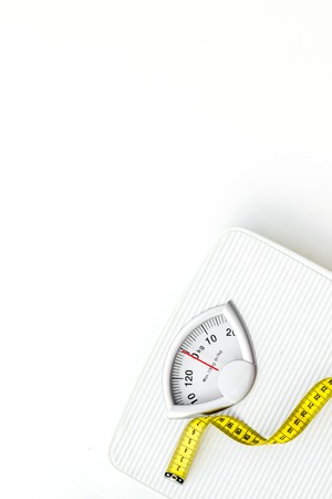 Diet. Bathroom scales and measuring tape for weight loss concept on white background top view space for textの写真素材