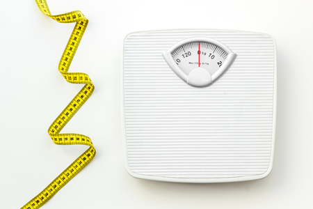 Diet. Bathroom scales and measuring tape for weight loss concept on white background top viewの写真素材
