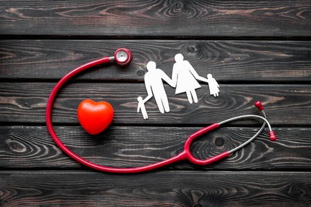 Office desk for doctor. Health care concept. Stethoscope and heart for diagnostic and cure of heart disease on wooden background top viewの写真素材