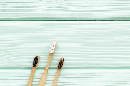 Dental care. Eco materials concept with bamboo tooth brush on mint green wooden background top view copy spaceの写真素材
