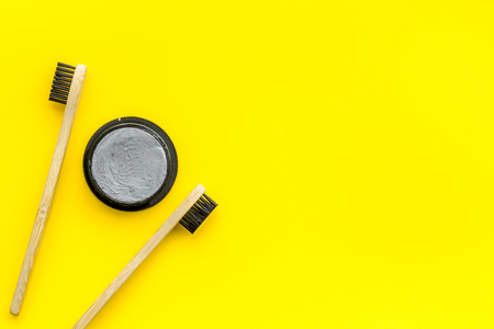 Dental care. Eco materials concept with bamboo tooth brush, toothpaste with bamboo carbon on yellow background top view copy spaceの写真素材
