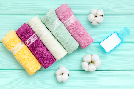 Washing of cotton products. Powder for laundry and cotton towels on mint green wooden background top viewの写真素材