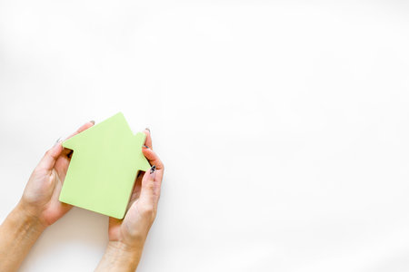 Property insurance concept with house toy in hands on white background top view mockupの写真素材