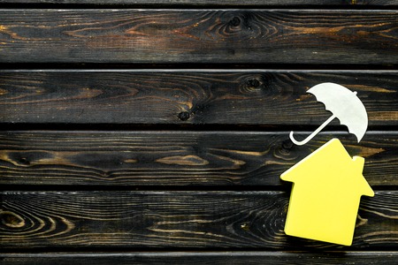 Mortgage credit concept with house and umbrella toys on wooden background top view copy spaceの写真素材